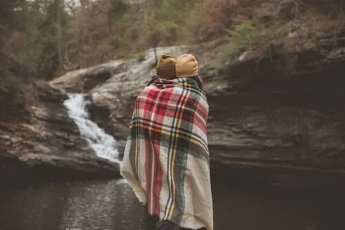 Couple with blanket in woods