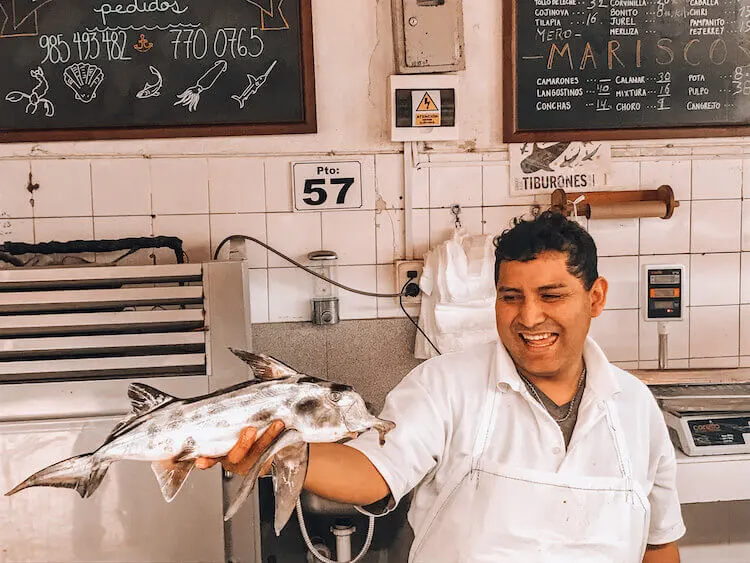 Man holding a fish at the local market in Lima, Peru - Peru itinerary