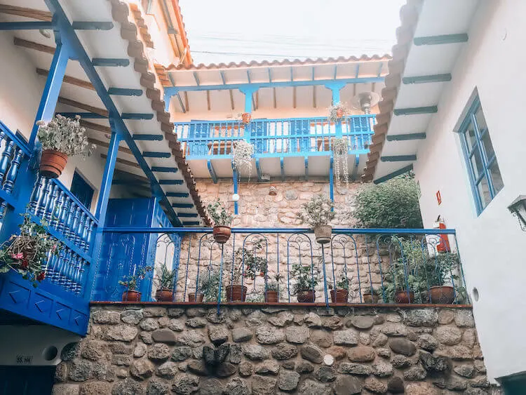 Rumi Wasi courtyard with blue railings and stone walls - Peru itinerary