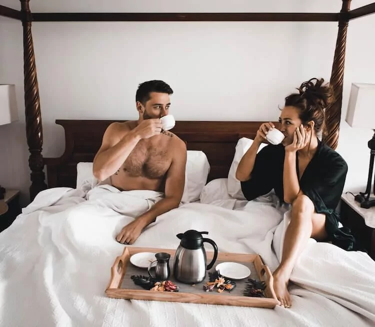 Couple sitting in bed and drinking coffee