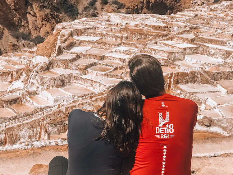 Kat and Chris sitting and relaxing while looking at the Maras Salt mines in Peru - Peru itinerary