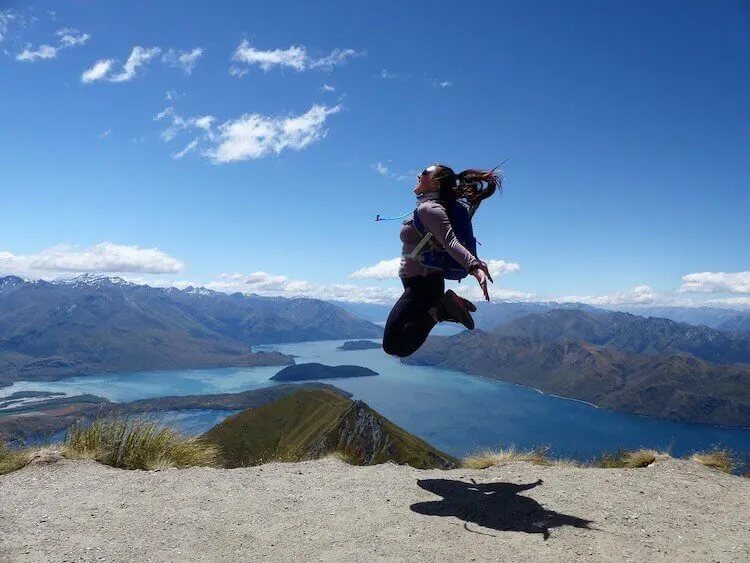 Christine jumping at Milford Sound, New Zealand