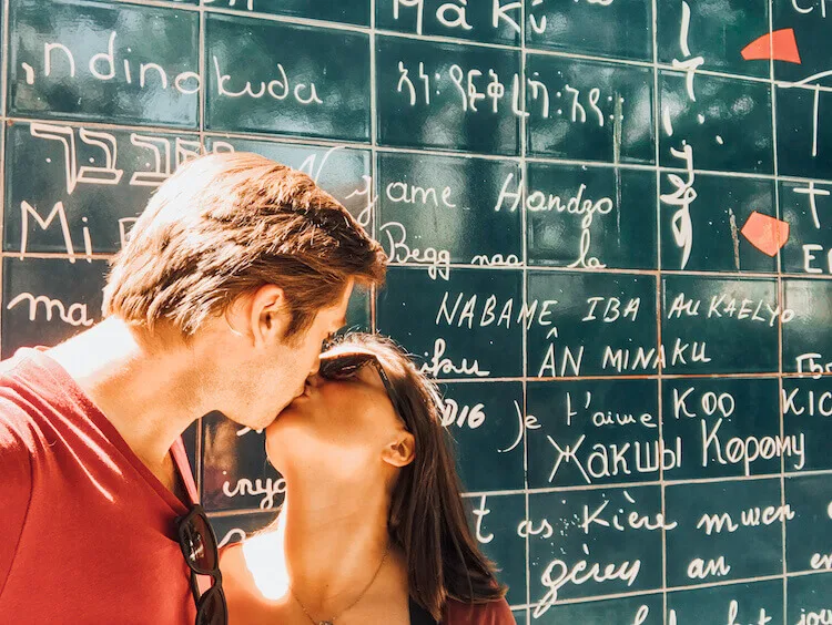 Kat & Chris kissing at the Love Wall in Paris, France