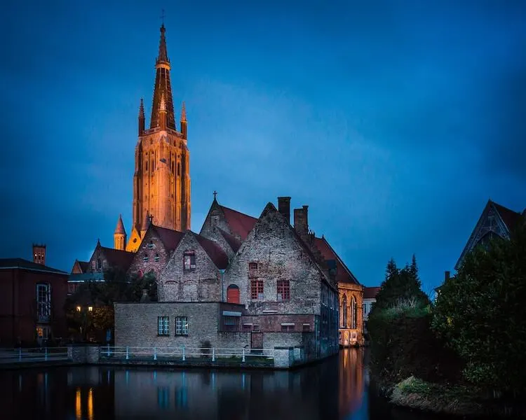 Bruges Belgium in the evening with the cathedral in the background and canals in forefront