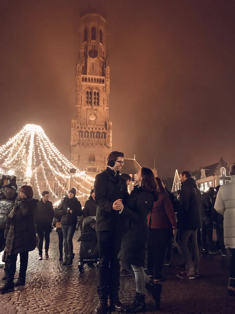 Kat and Chris at the Bruges Christmas market in front of the Belfry-Things to do in Bruges