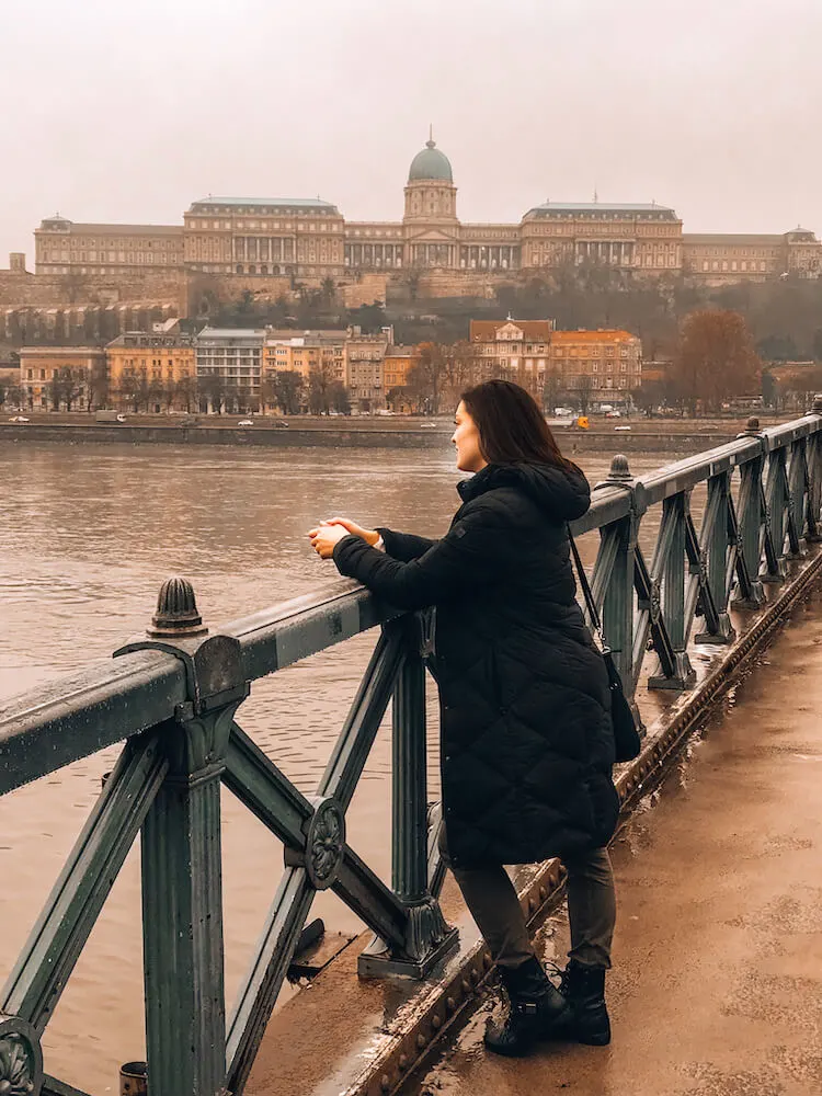 Kat staring at the Danube River from the Chain Bridge in Budapest - Top Things to do in Budapest