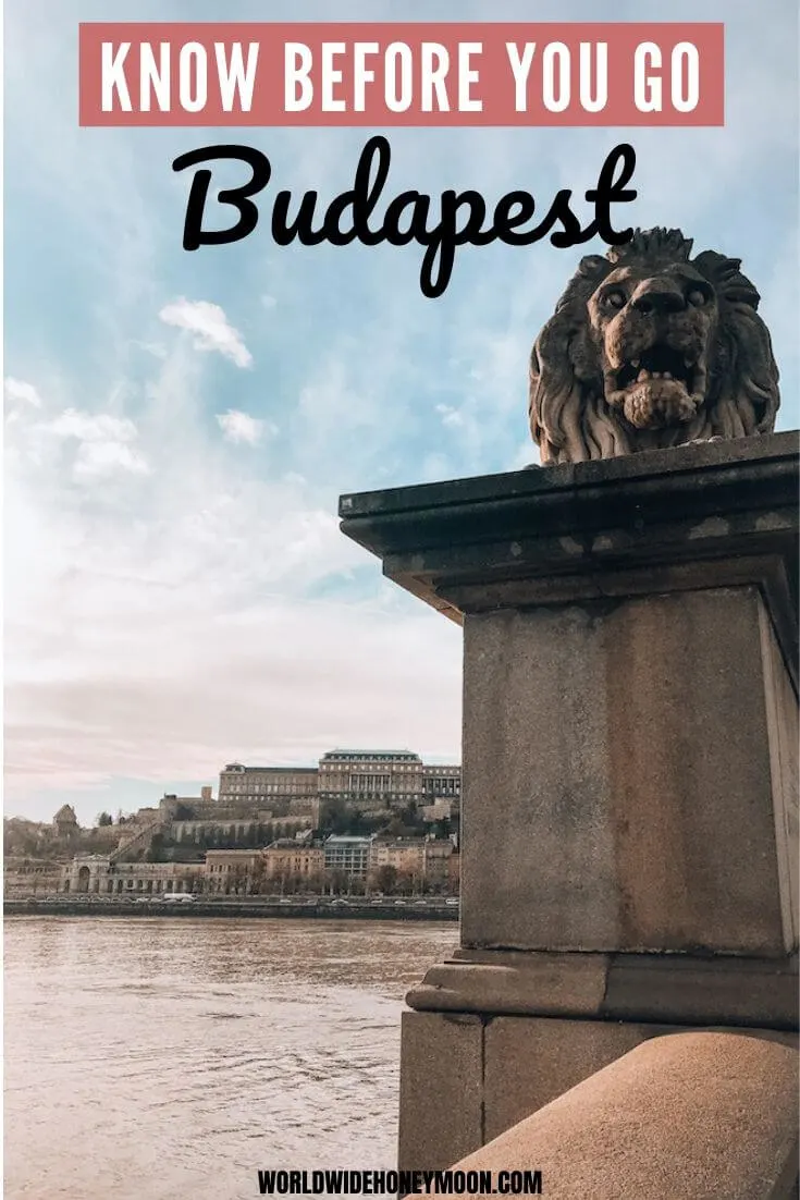 Know Before You Go Budapest | Photo pictured is the lion statue from the Chain Bridge in the foreground with the Danube River and Buda Castle in the background