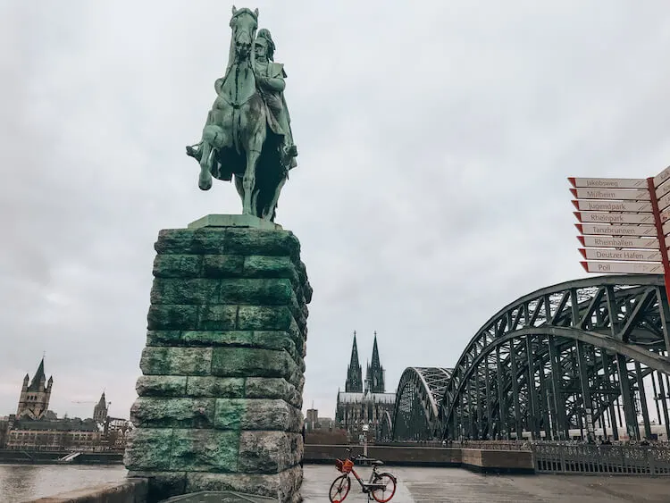 statue in front of the bridge and Cologne Cathedral