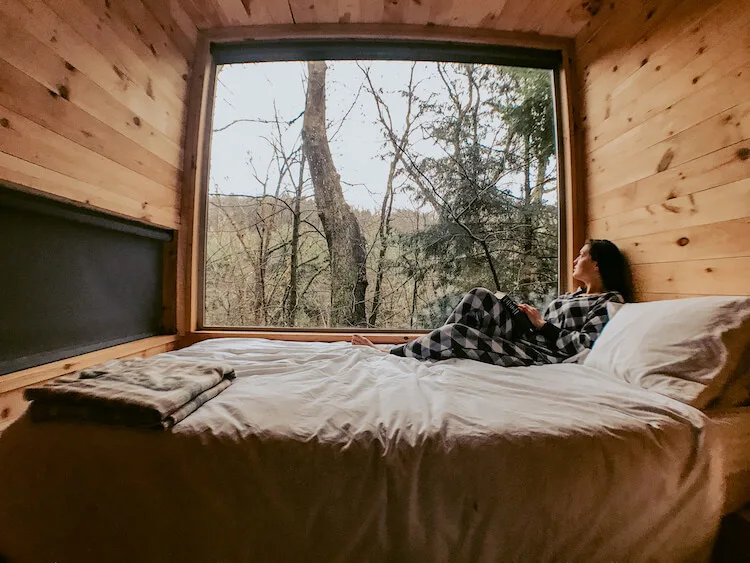 Kat looking out of the window while relaxing in her pj's in the romantic cabin