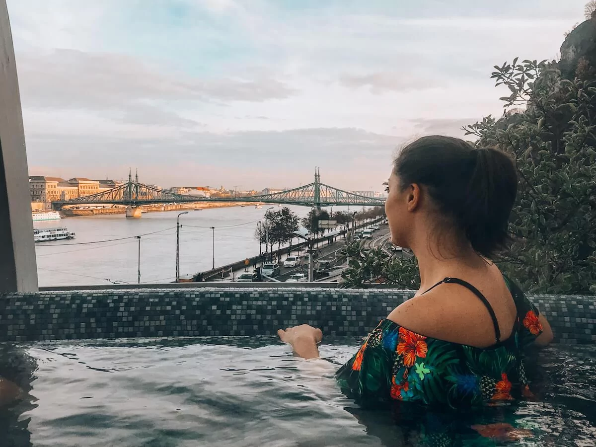 Kat looking out over the Danube River while sitting in the rooftop hot tub at Rudas Baths