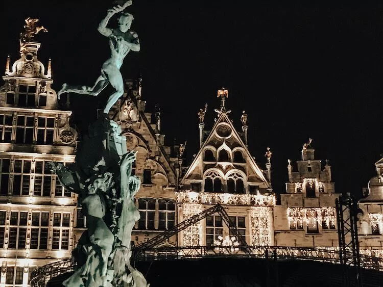 One Day in Antwerp at night with a statue of Brabo throwing the hand