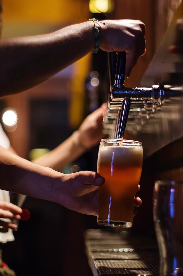 Bartender pouring a beer from a tap