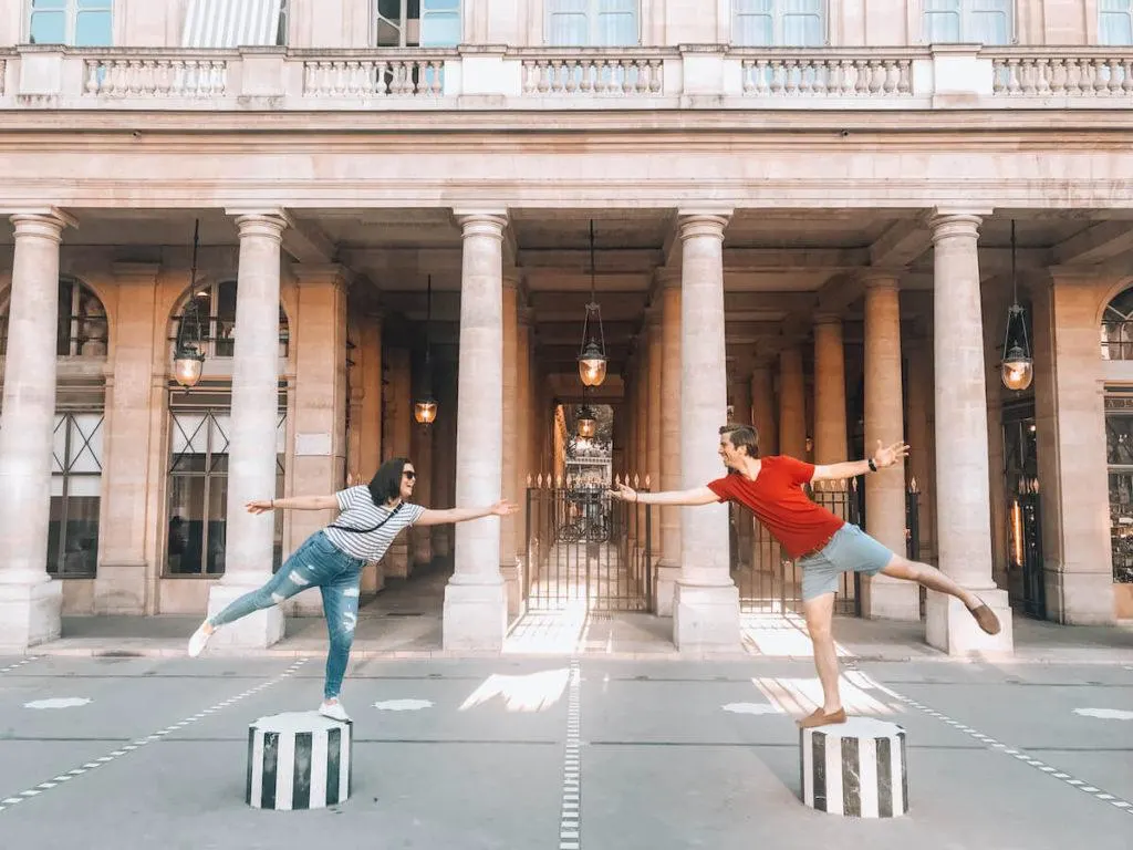Kat and Chris balancing on cylinders at Palais Royale- What to Wear in Paris