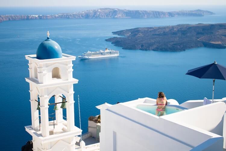 Woman in a plunge pool in Santorini- Couple's Travel Bucket List