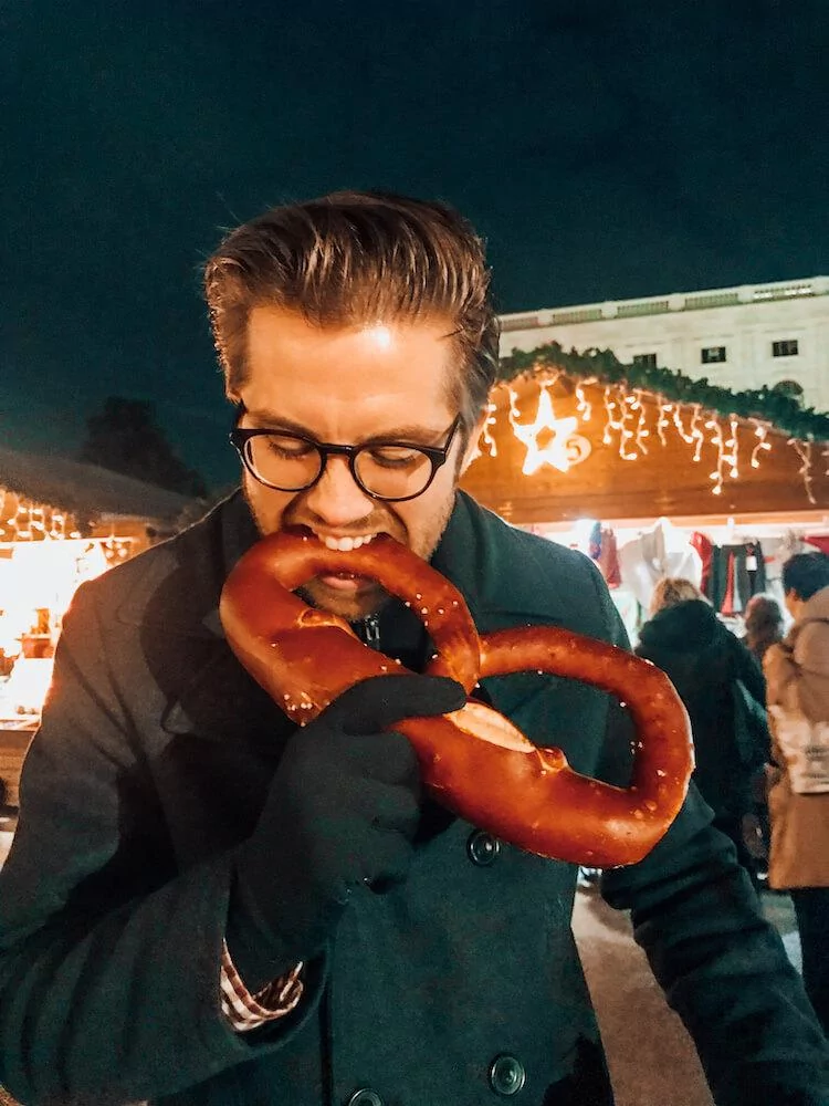 Chris enjoying a salt pretzel during Christmas in Vienna