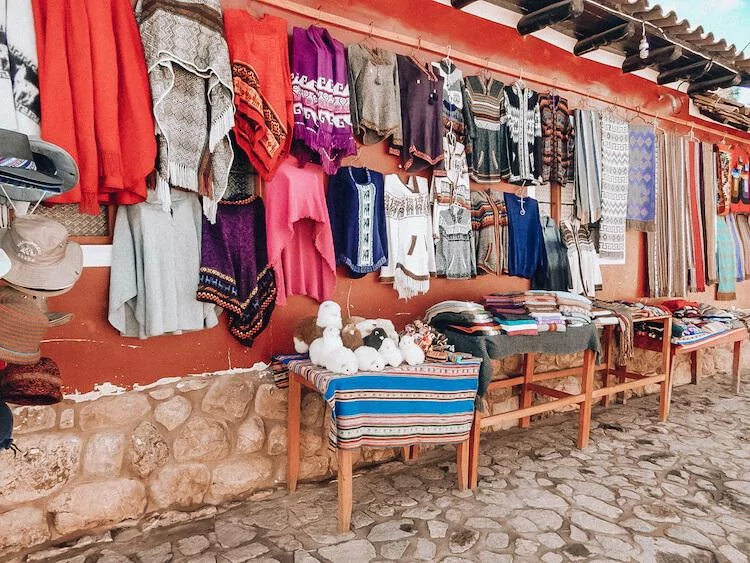 Peruvian souvenirs at a market in the Sacred Valley including textiles, alpaca dolls, and scarves