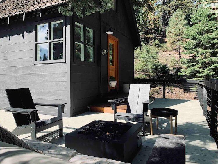 Black Cabin with black deck chairs around a modern firepit in Lake Tahoe