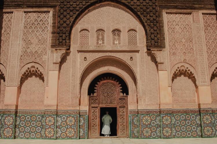 Person standing in the doorway of an intricately designed building in Morocco