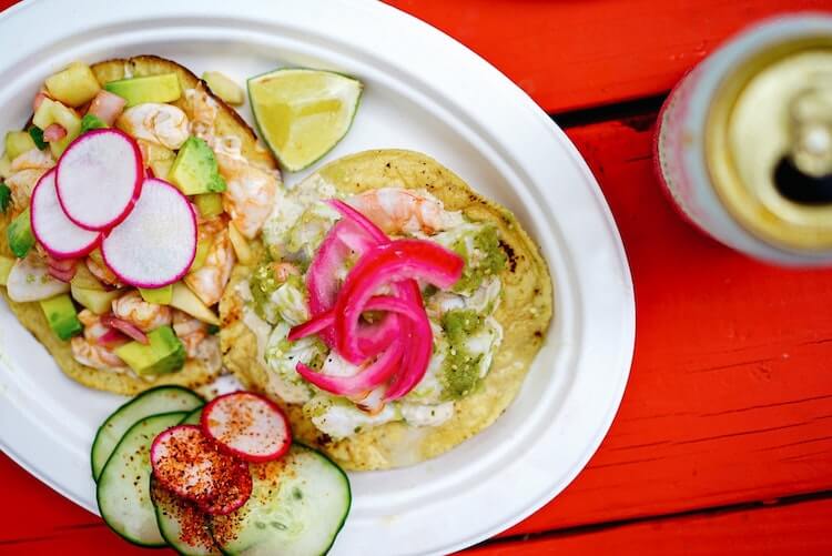 Weekend in Austin | shrimp tacos on a paper plate topped with lime, pickled onions, radishes, avocado, and salsa verde