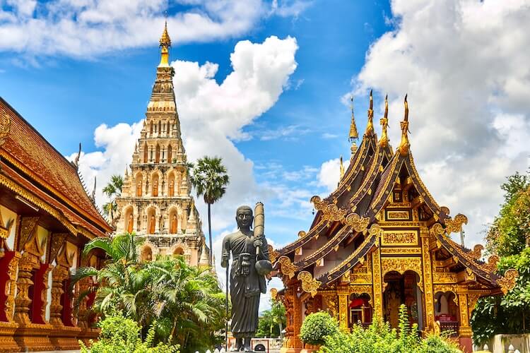 Temples and a Buddha statue on a sunny day in Thailand