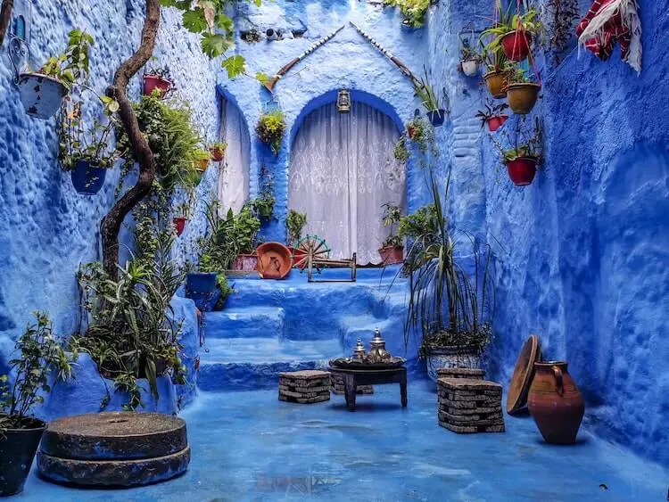 Chefchaouen in Morocco blue city with plants framing a door and seating area