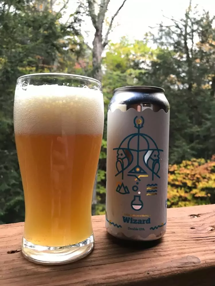It's Complicated Being a Wizard beer can next to a full beer glass with the woods in the background | Vermont Beer | Best Vermont Breweries