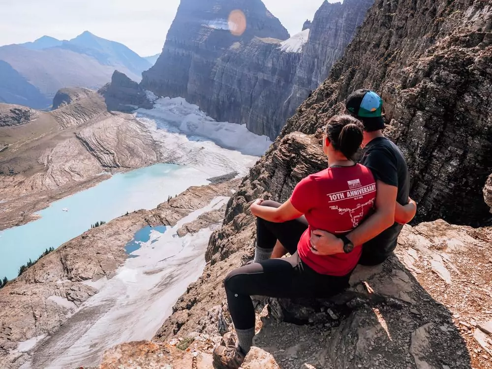 Kat and Chris looking at Grinnell Glacier and embracing from the Grinnell Glacier Overlook