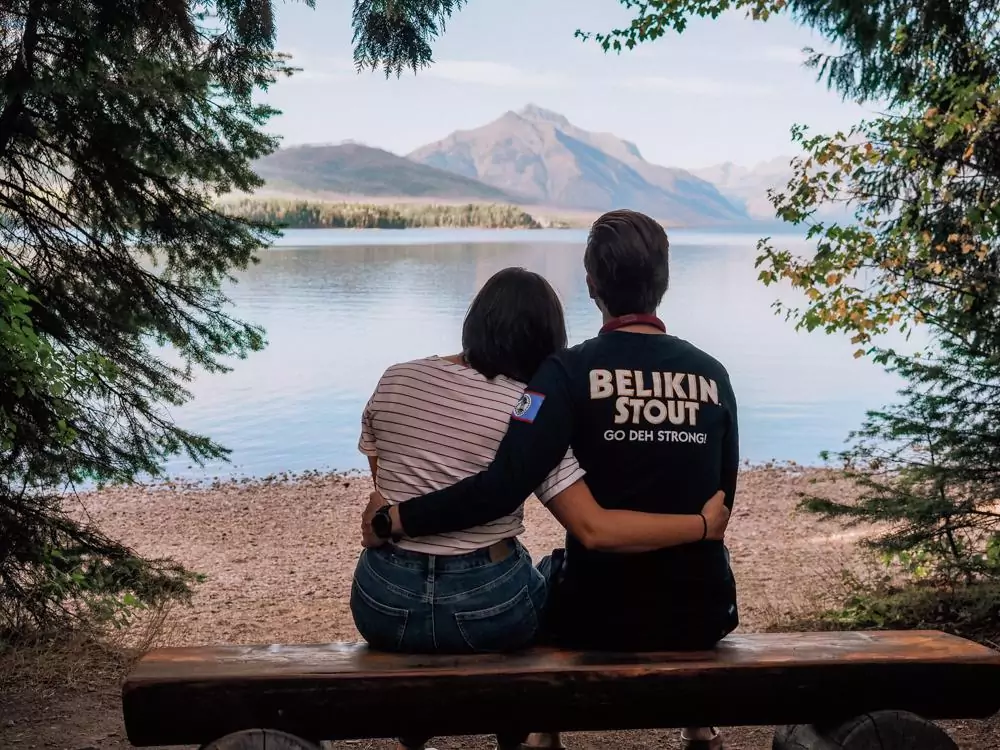 Kat and Chris with their arm around each other and looking on Lake McDonald while watching the sunset