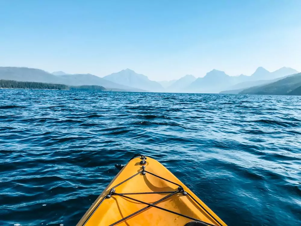 Kayak in the water facing the mountains at Lake McDonald | 7 Days in Glacier National Park