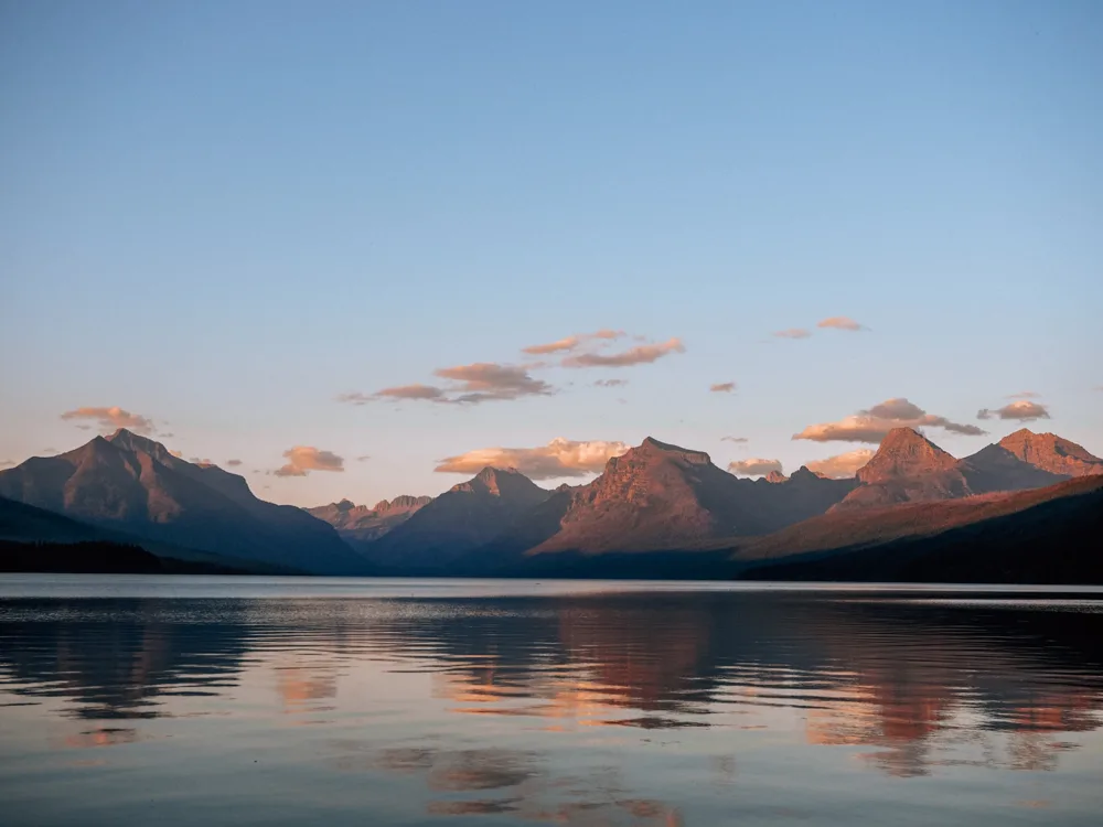 Lake McDonald at sunset with the mountains in the background | Itinerary For Glacier National Park