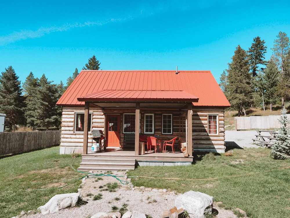 Outside our cabin in West Glacier with log cabin and red roof | Best way to spend 7 days in Glacier National Park