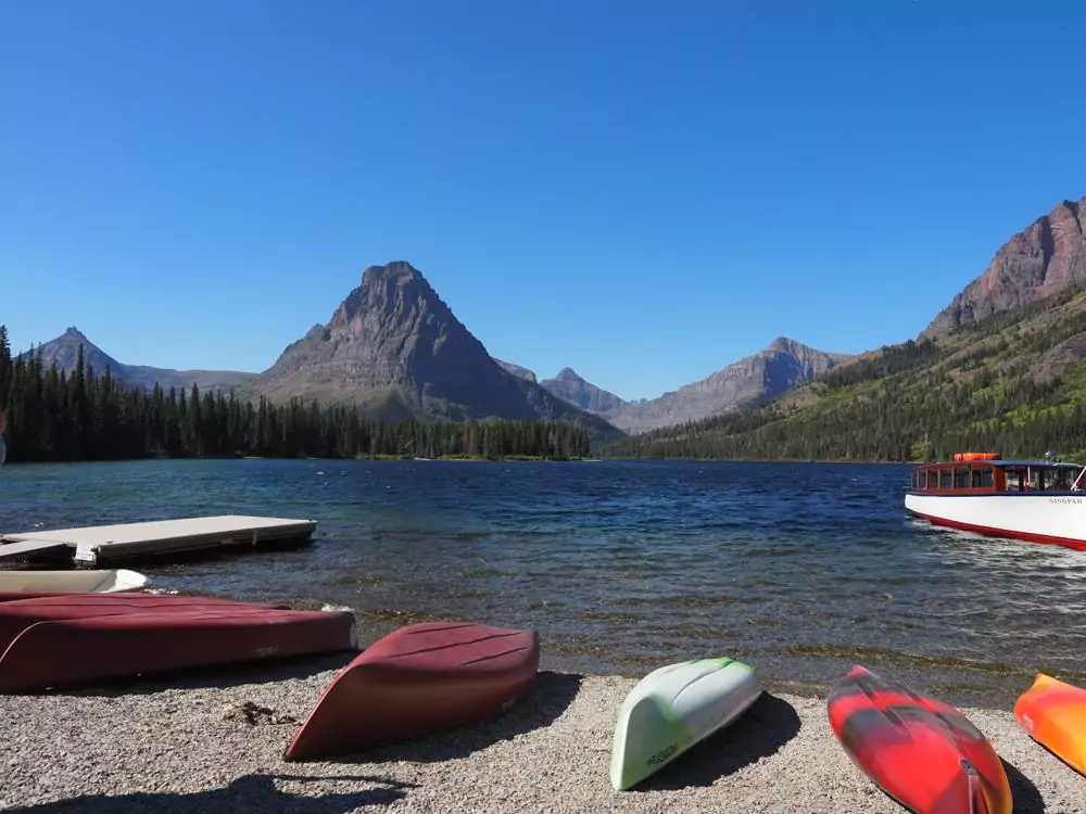 Two Medicine Lake with kayaks resting on the shore turned upside down