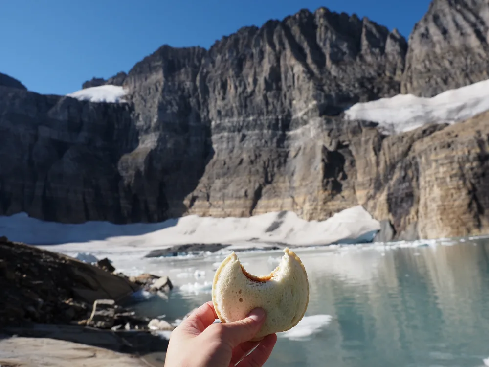 Uncrustable with a bite out of it in the foreground with Grinnell Glacier in the background