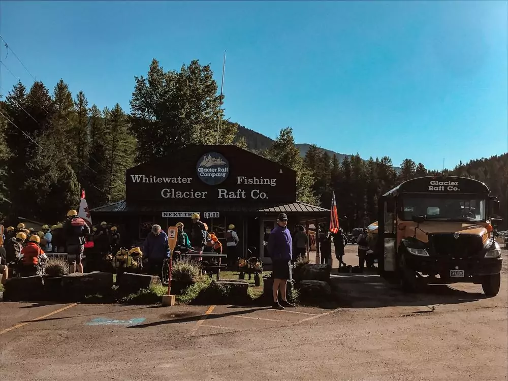 Whitewater Rafting at Glacier Rafting Company | yellow schoolbus on the right facing the camera and people gathered around waiting to start their ride