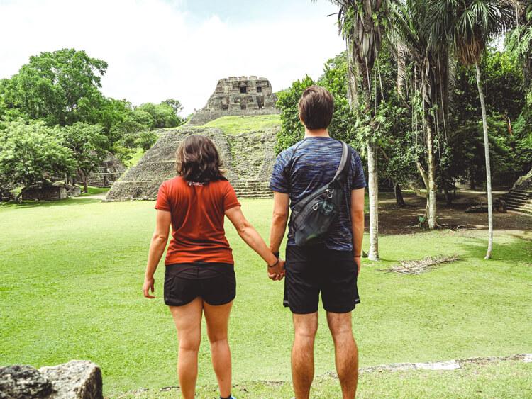 Kat and Chris holding hands and looking at the ruins of Xunantunich