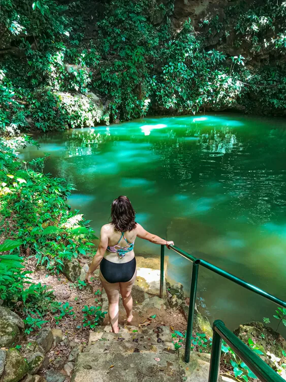 Kat walking into a cenote in Belize - Belize Itinerary