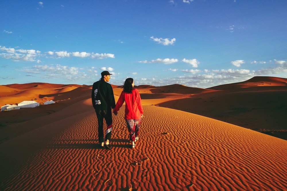 Couple walking along a dune at Erg Chebbi
