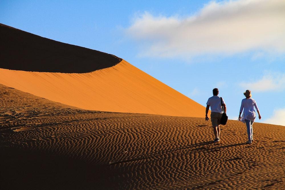 Couple walking on a dune in Sossusvlei, Namibia