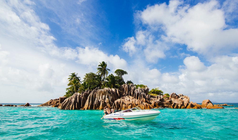 Seychelles | And island with a boat in front