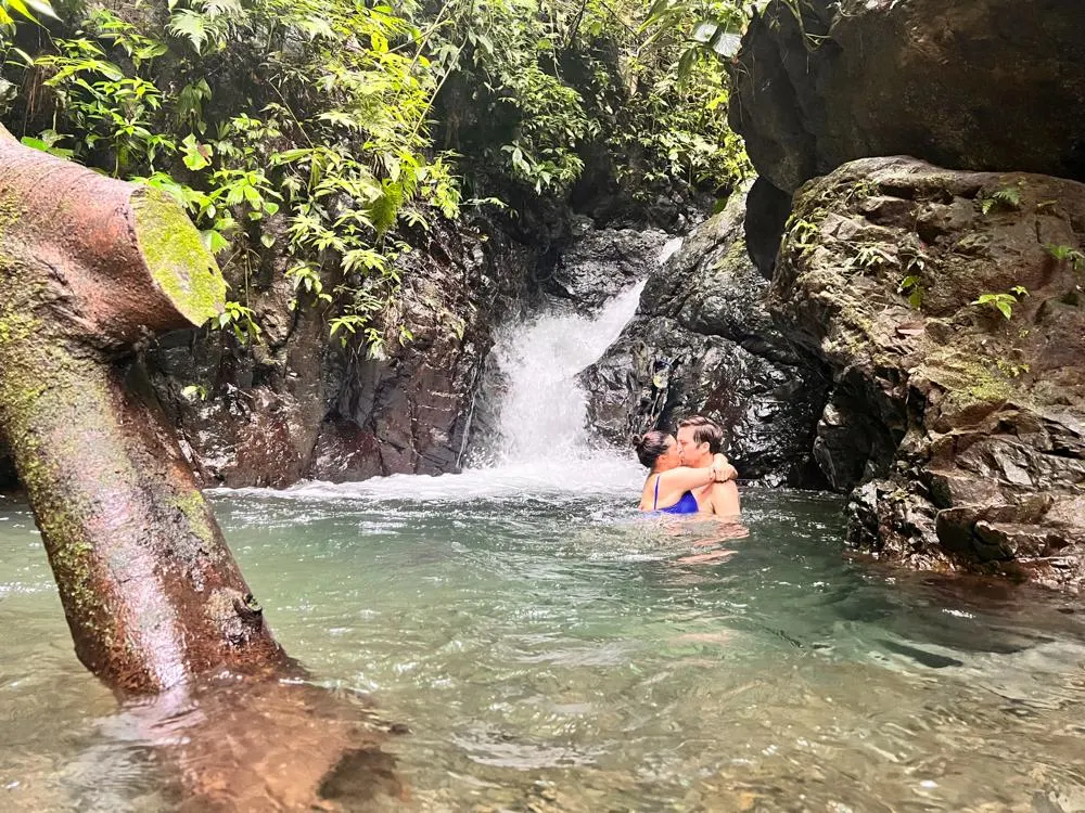 Kat and Chris kissing in a waterfall pool