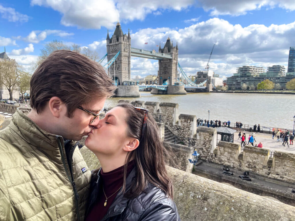 Chris and Kat kissing in front of Tower Bridge