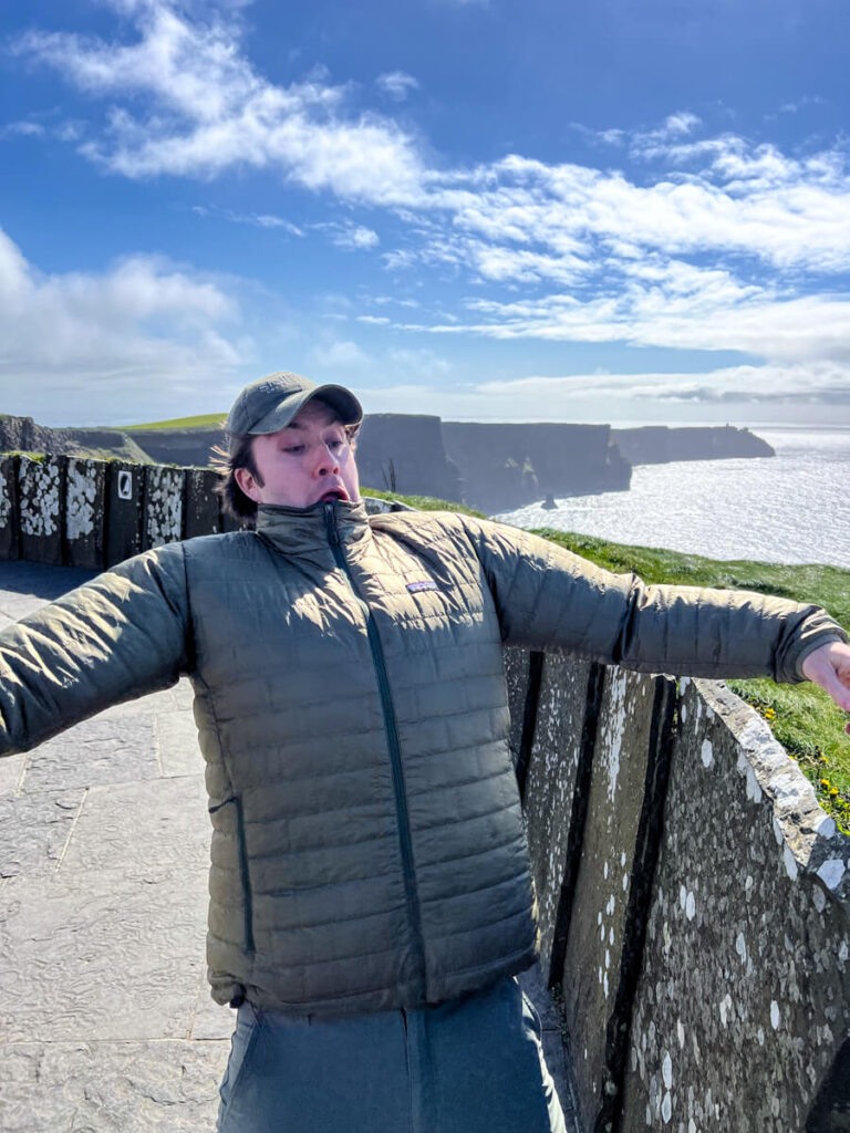 Chris with his coat blowing in the wind at Cliffs of Moher