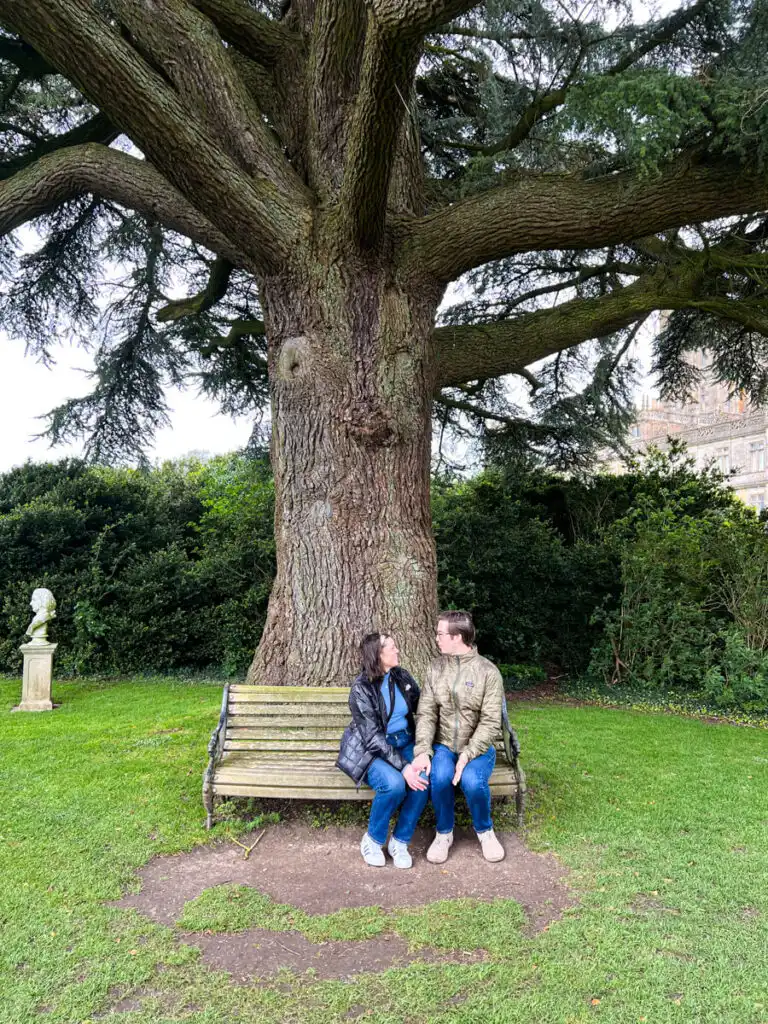 Kat and Chris at Highclere Castle (AKA Downton Abbey) sitting on a bench