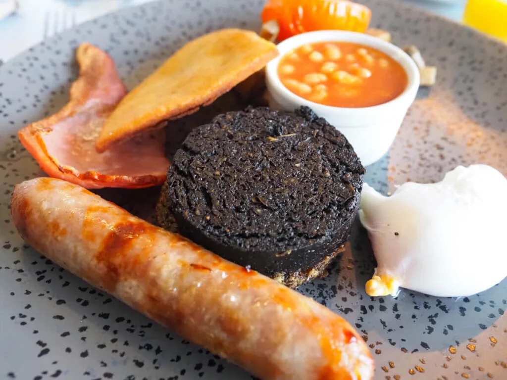 Scottish breakfast of haggis, sausage, bacon, beans, and egg