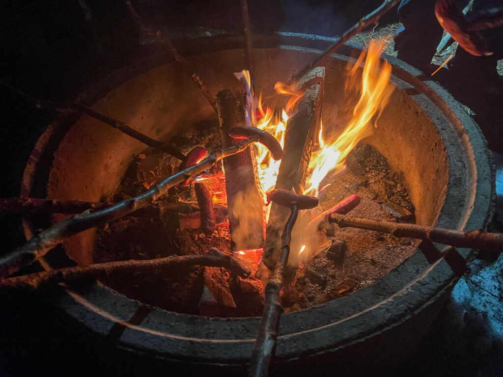 Roasting reindeer sausages over the fire