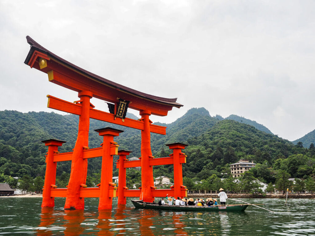 Boat going through the red torii gate in Miyajima