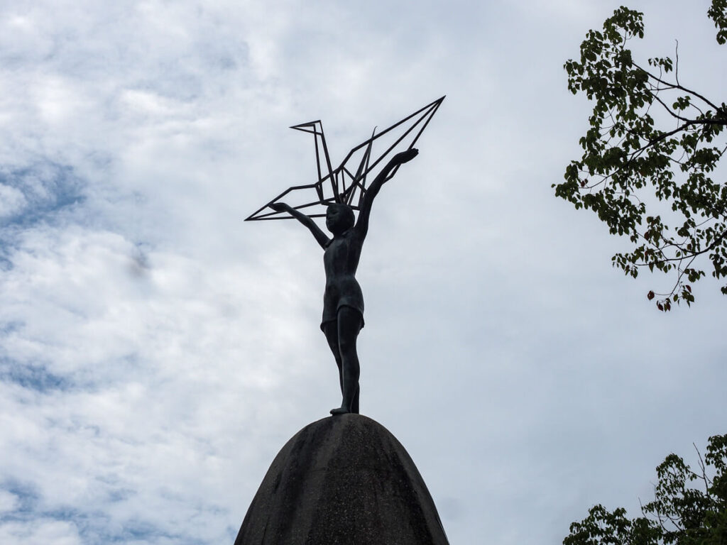 Children's Peace Monument in Hiroshima close up with a girl statue holding up a metal crane