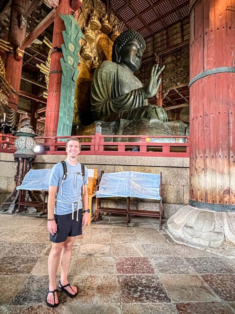Chris smiling in front of a side angle view of the Diabatsu of Nara