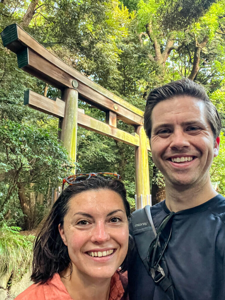 Kat and Chris smiling at the camera in front of a torii gate