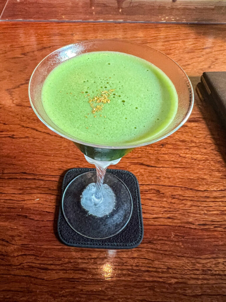 Matcha cocktail with gold flakes on a counter